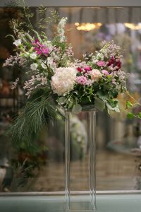 Ovale Tischdekoration auf transparenten Beinen (Hortensie, Wildblumen, Rosa, Weiß)