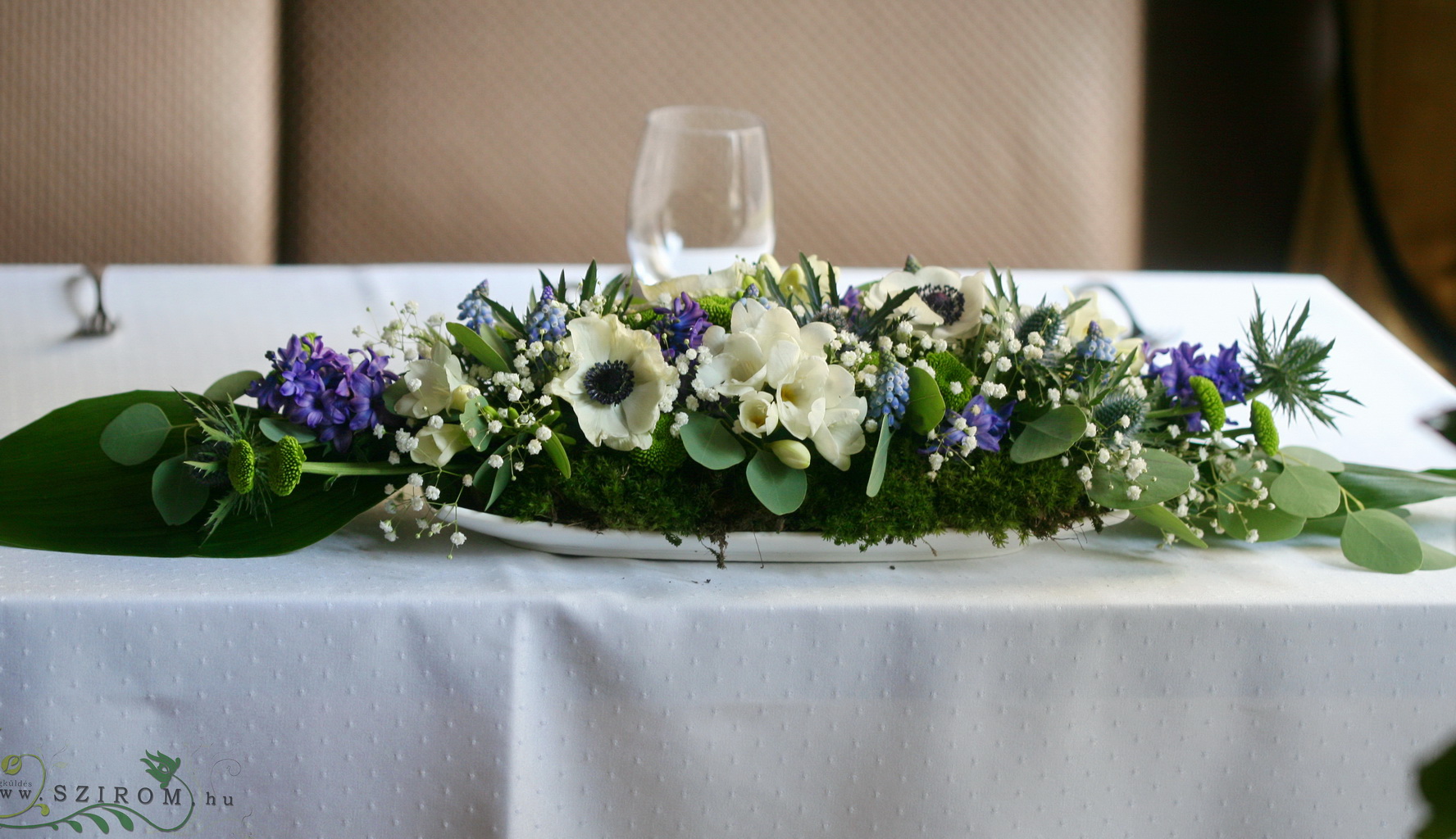 Virágküldés Budapest - Főasztaldísz tavaszi virágokkal, mohával, Mezzo Music (jácint, szellőrózsa, iringó, vadvirágok, frézia, kék, fehér), esküvő