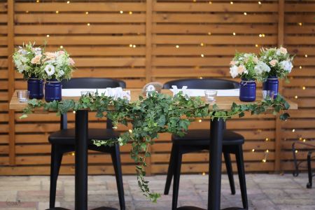 Main table centerpiece with ivy, A KERT Bisztró Budapest (lisianthus, wild flowers, ivy, white, peach, blue)