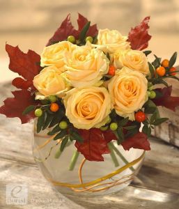 Cream roses in an autumn bouquet in glass ball