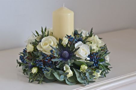 Centerpiece with dark blue eryngium and berries and candle