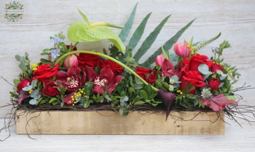 Modern arrangement in wooden box, with red roses ad orchids
