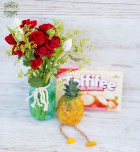 Kleine Vase mit roten Rosen, Tulpen, Ananasfiguren und weißer Schokolade