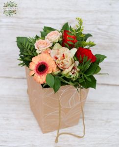 small peach-red bouquet in a portable flower bag with ears