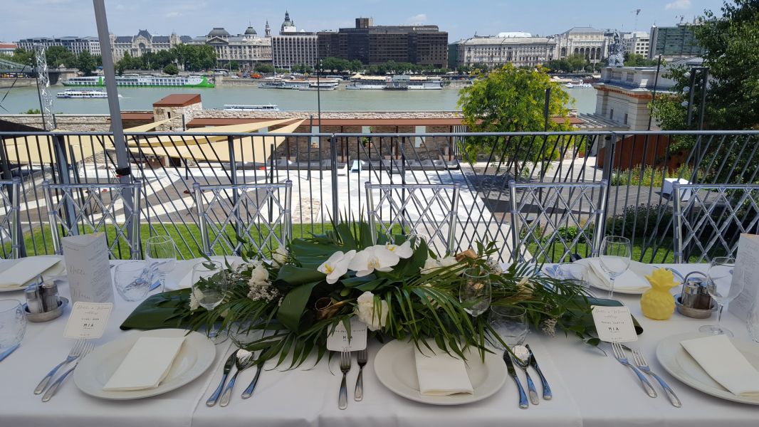 Esküvői asztaldísz, Bazaar Eclectica Étterem Budapest (phalaenopsis orhidea, monstera, pálmalevél, fehér, zöld, arany)