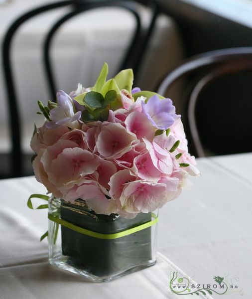 Asztaldísz üvegkockában (hortenzia, frézia, orhidea, rózsaszín, lila, zöld)  Városliget Caffé Étterem, Budapest, esküvő
