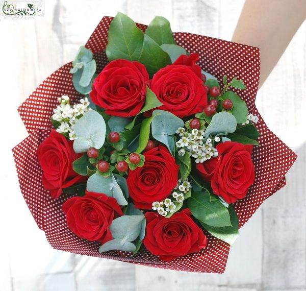 7 red roses in a round bouquet with small flowers and hypericums