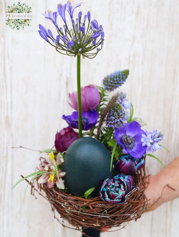 Fészek csokor tojással, lila tavaszi virágokkal