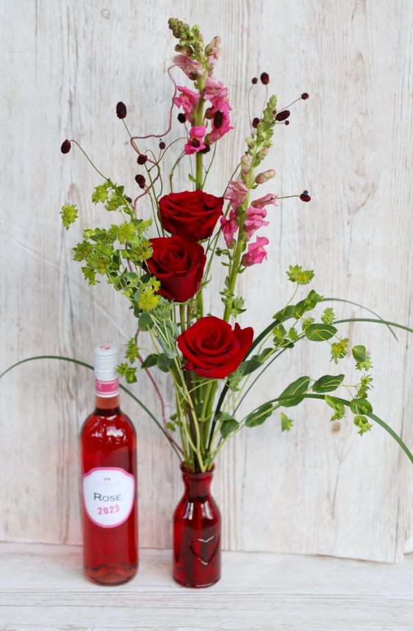 Red rose bouquet in vase, with rozé wine 