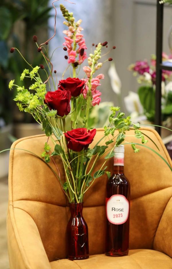 Red rose bouquet in vase, with rozé wine 