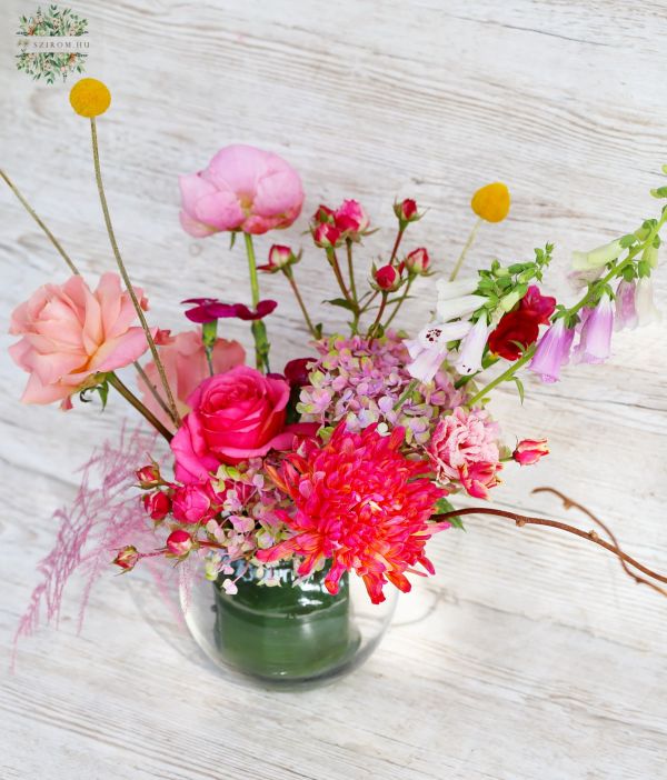 Luftiger Tafelaufsatz mit Saisonblumen in Glaskugel (rosa, rot, pfirsich)