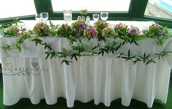 Main table centerpiece with passion flowers (hydrangea, lisianthus, purple), wedding