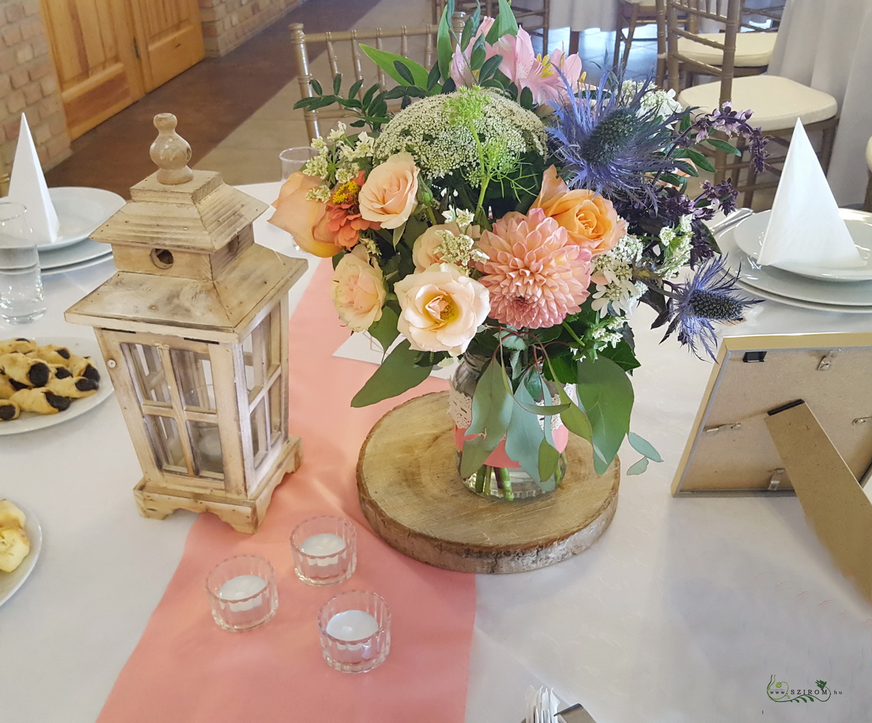 Esküvői asztaldísz fakorongon, lámpással, Szent Anna Fogadó Berkenye (bokros rózsa, dália, mezei virágok, barack)