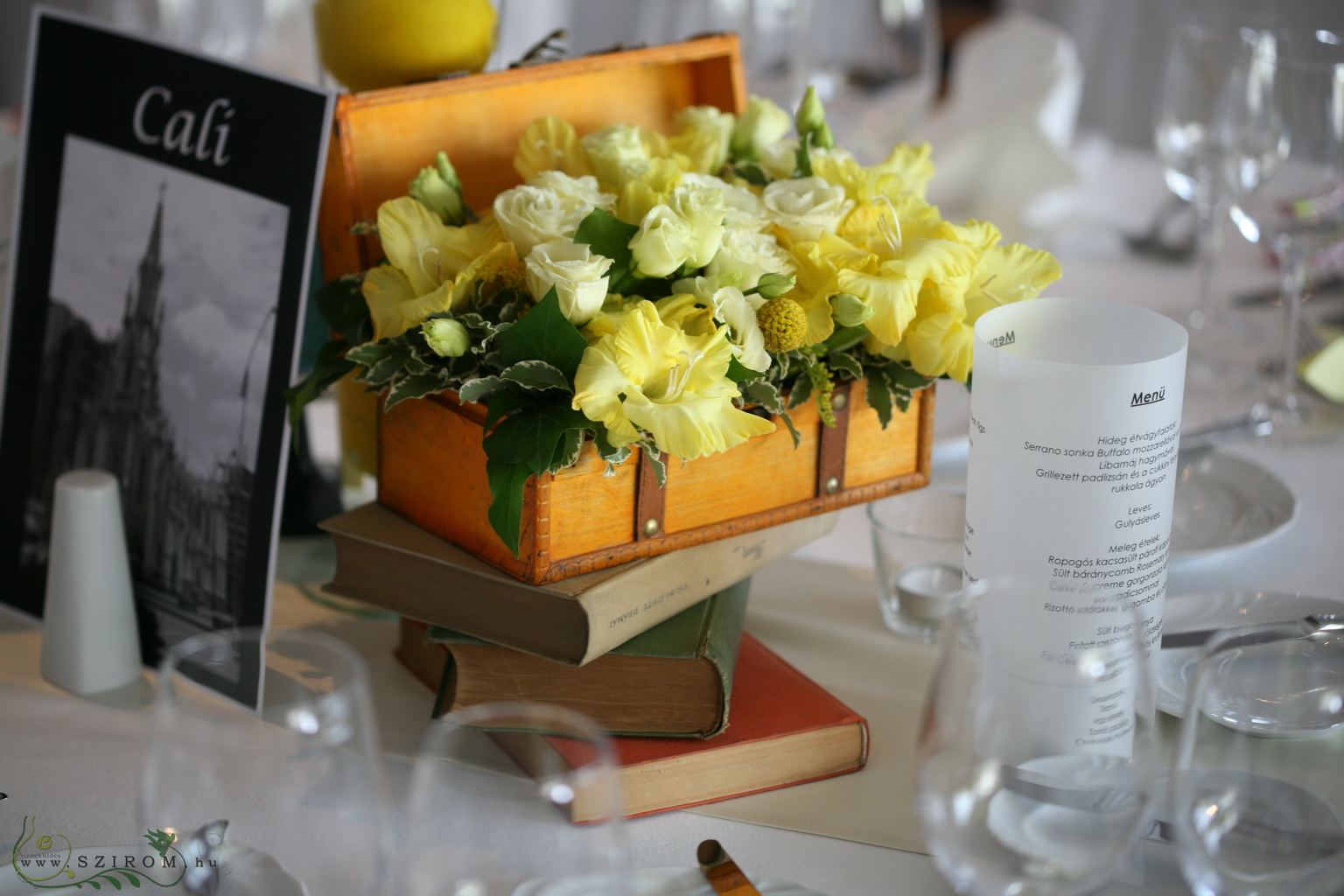 Esküvői asztaldísz citromokkal, könyvekkel, Marriott Budapest (kardvirág, liziantusz, sárga)
