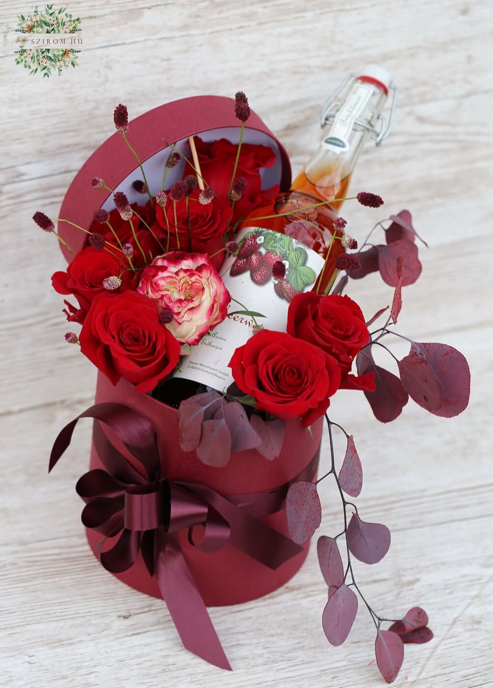 Blumenlieferung nach Budapest - Fruchtwein zwischen roten Rosen in Zylinderbox (8 Stiele)